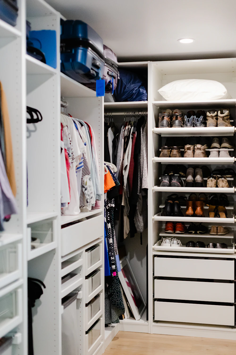 Organized small closet with shelves, drawers, hanging clothes and shoes