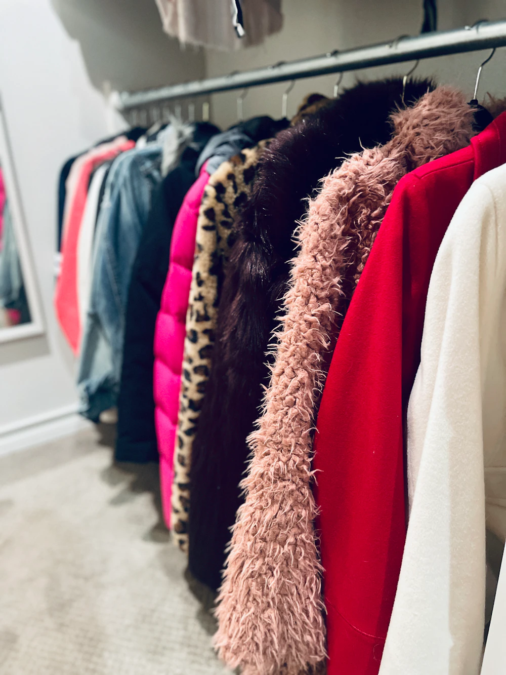 Coats arranged neatly on a closet rod for seasonal wardrobe rotation