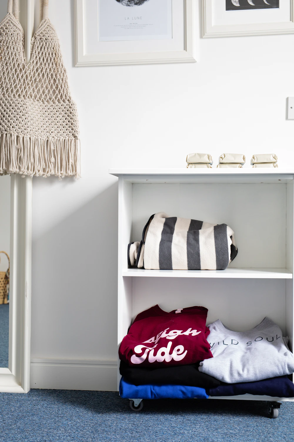 Folded seasonal clothes stored neatly on a closet shelf