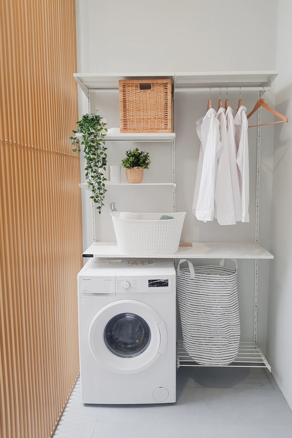 Small laundry room with shelves and baskets above the washing machine