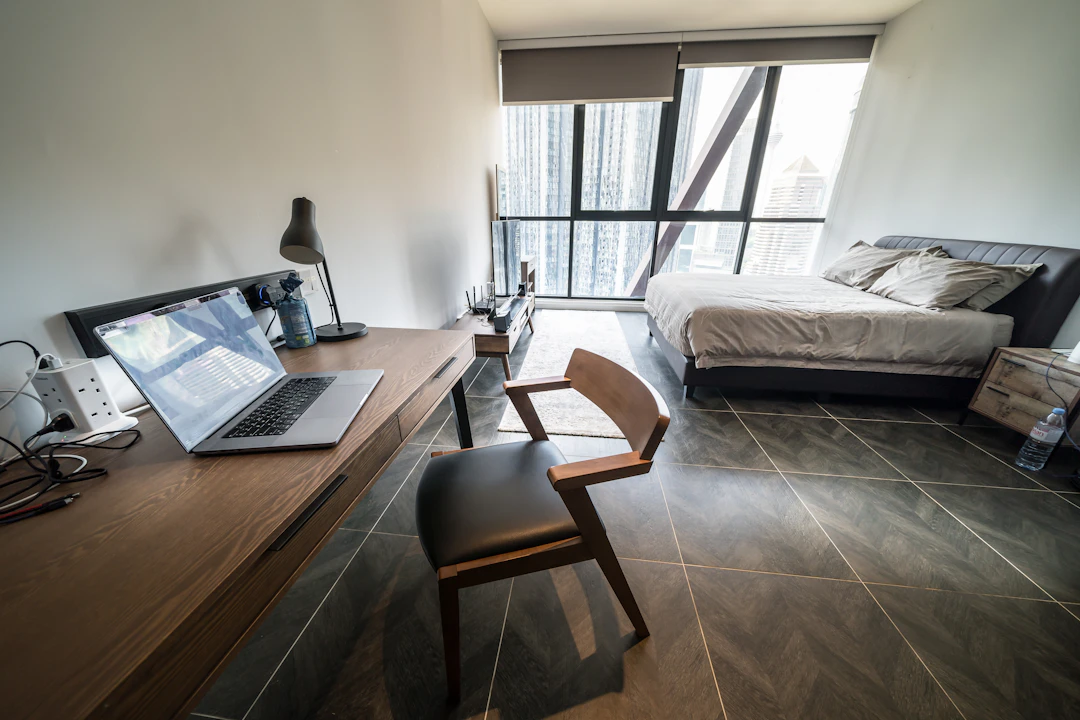 Minimal studio bedroom with desk, bed and large window