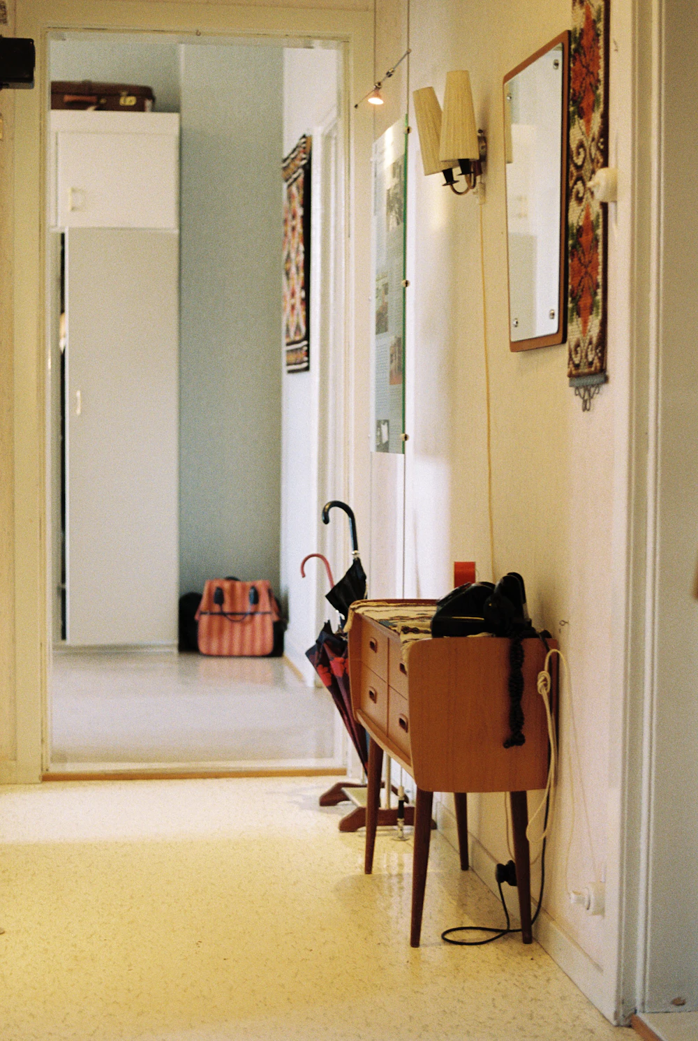 Narrow entryway with a small table, mirror and umbrella storage