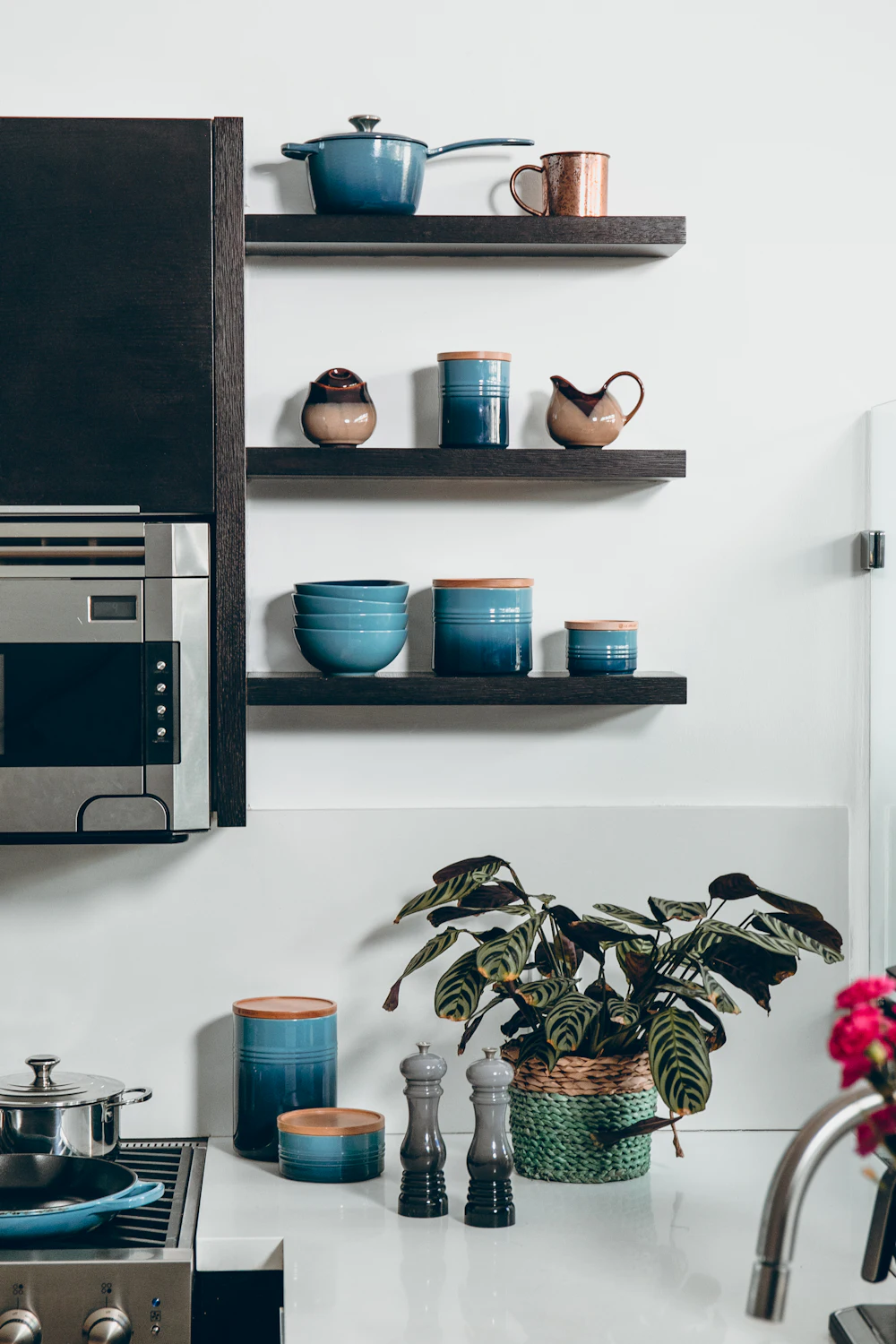 Small kitchen using open shelves above a microwave for extra storage