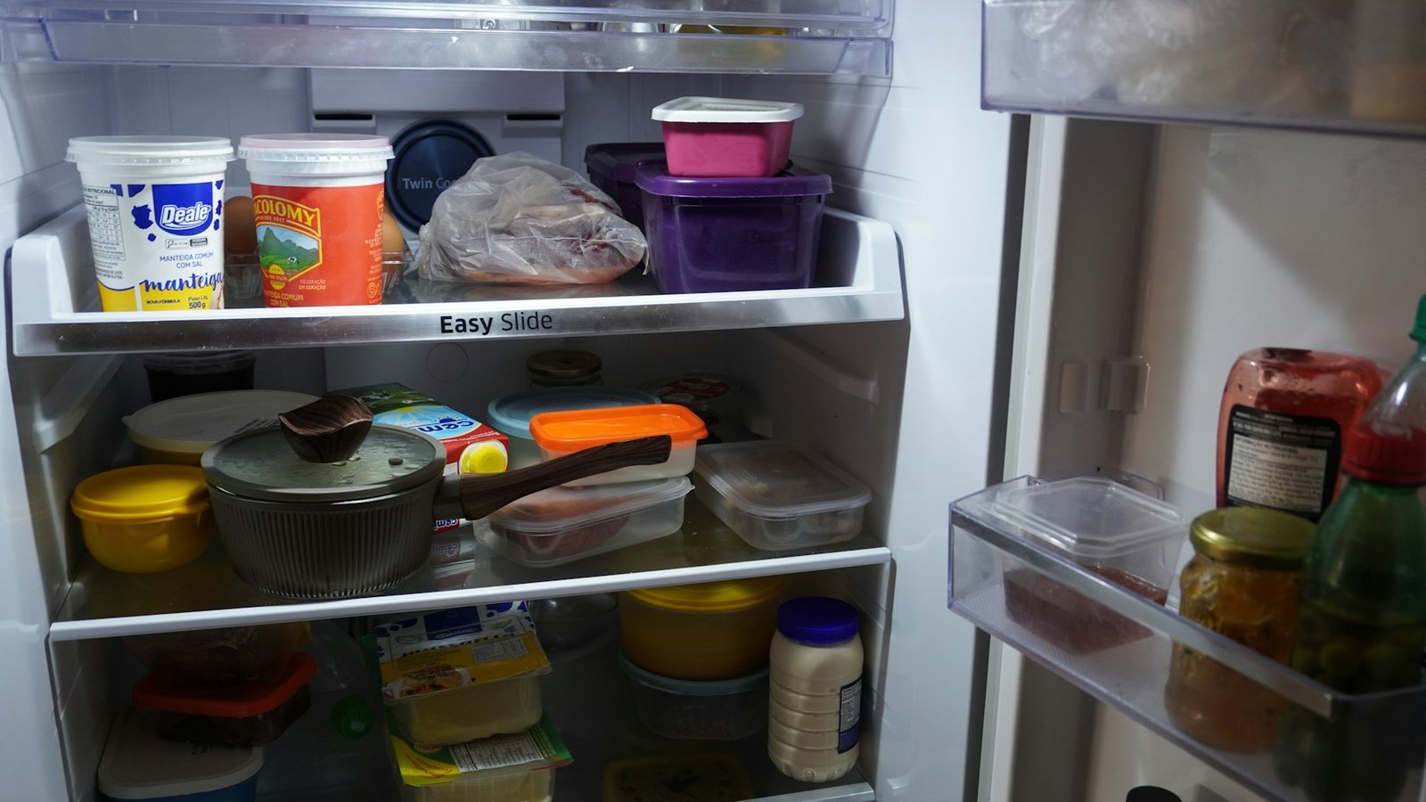 Open refrigerator with food containers organized on shelves
