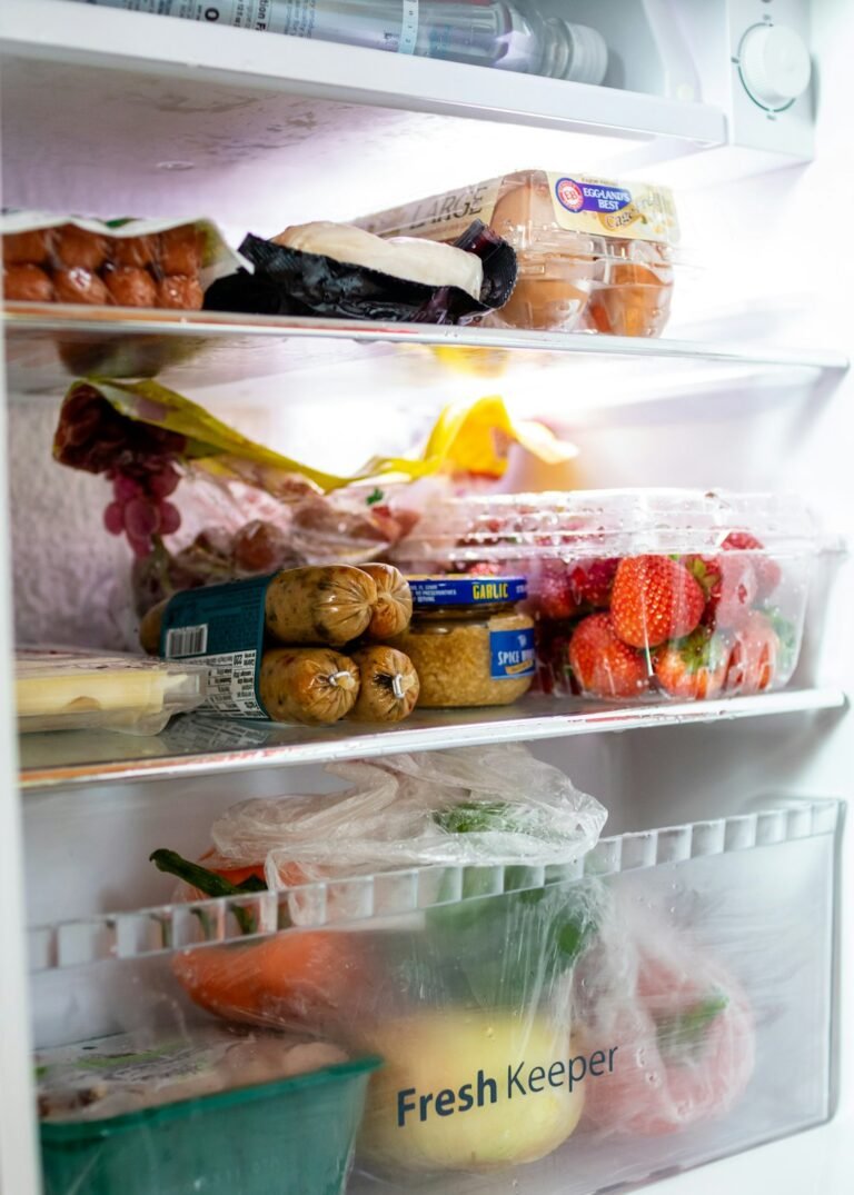 Open compact refrigerator stocked with food for small fridge organization
