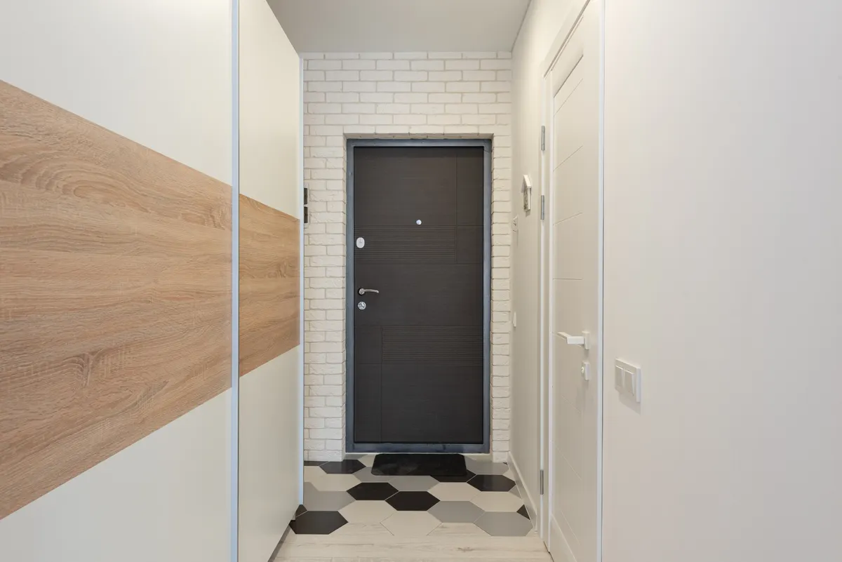 Compact apartment corridor with doors and a runner rug
