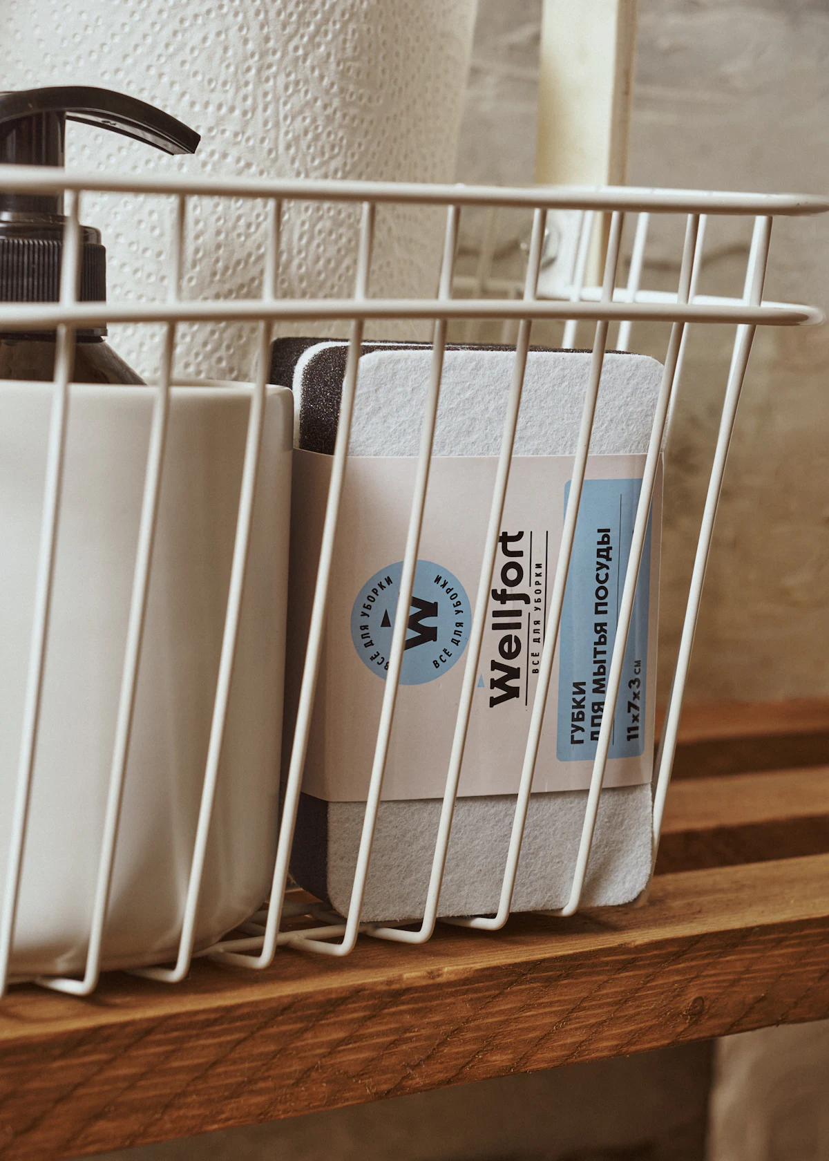 Soap and lotion arranged in a basket on a bathroom shelf