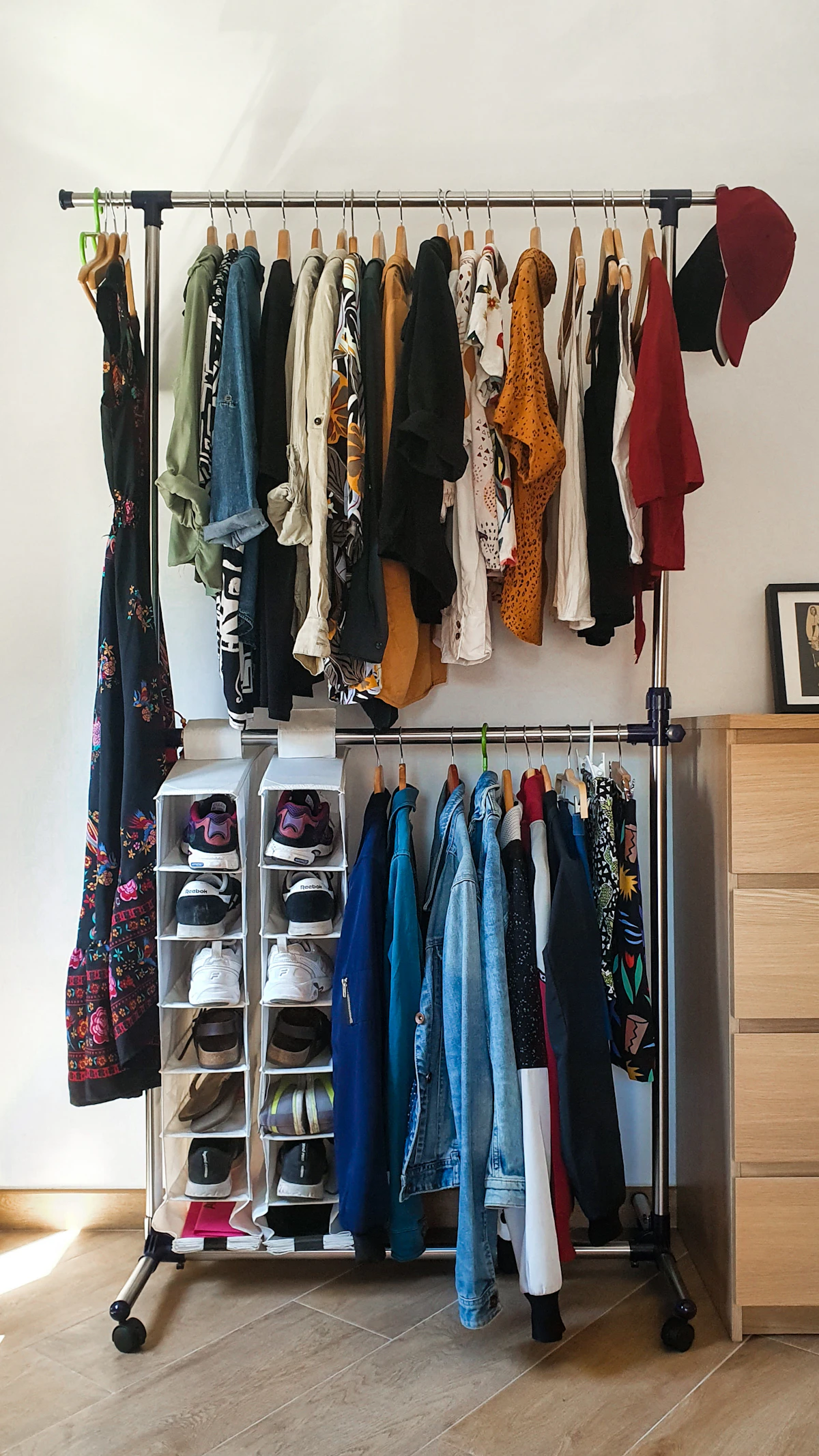 Freestanding garment rack with hanging clothes and lower shelf storage