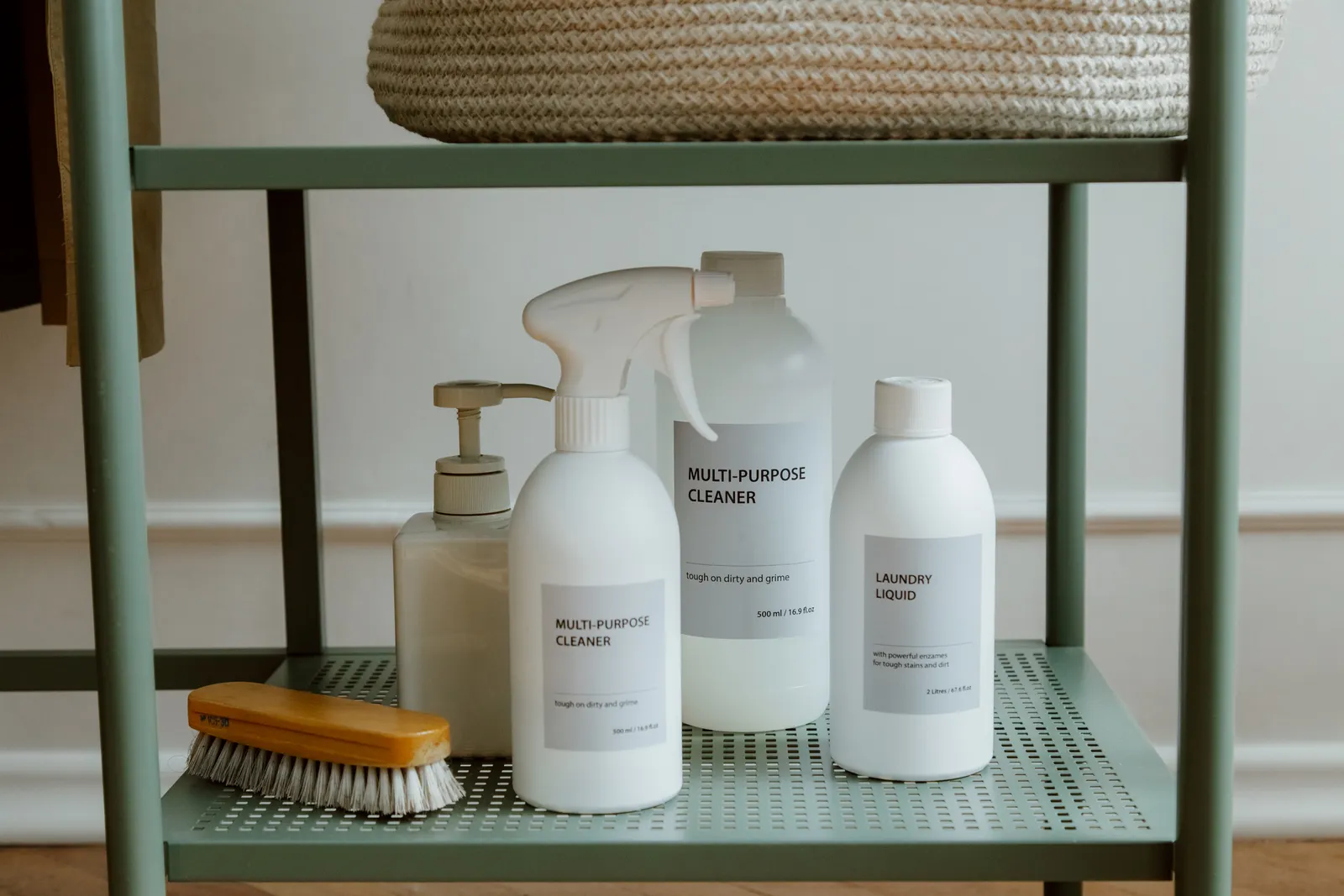Laundry and cleaning products grouped on a shallow open wall shelf
