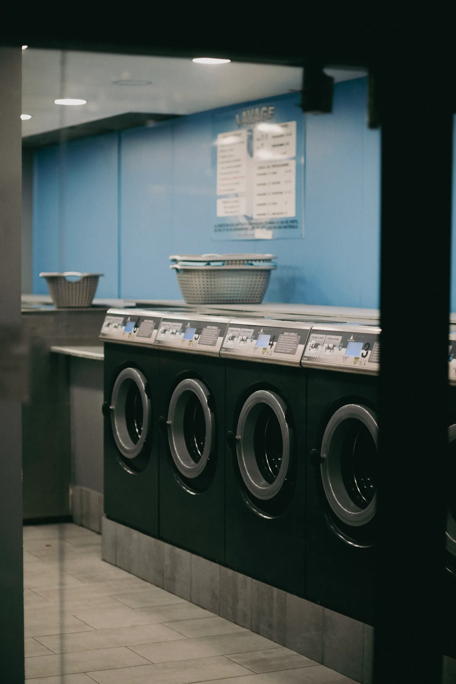 Narrow bright laundry room with open white shelves along the wall
