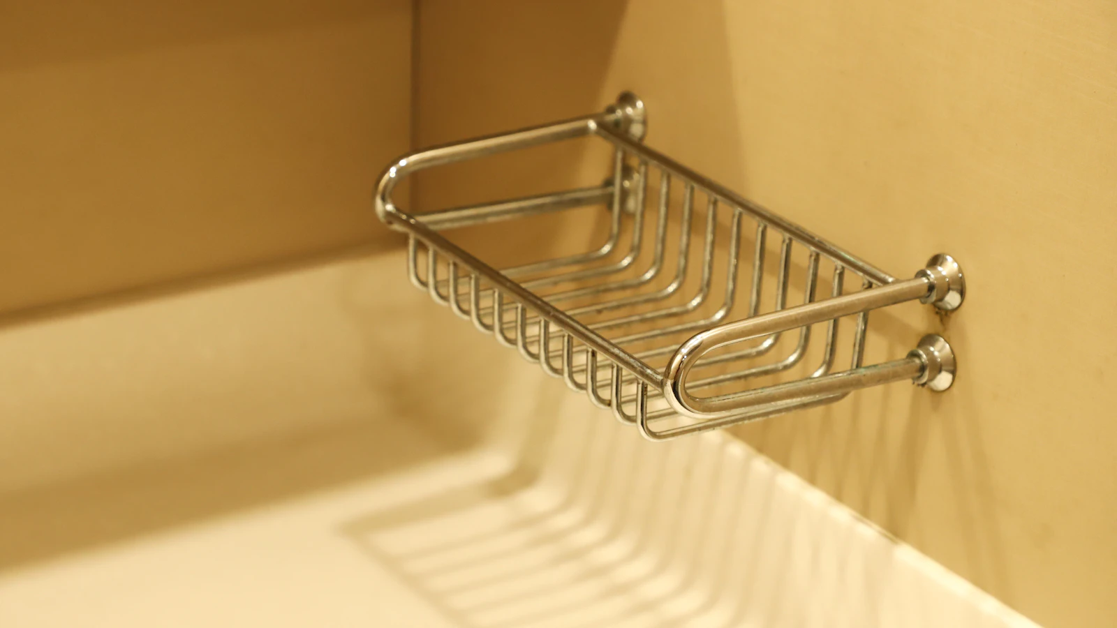 Metal shower rack mounted against a light bathroom wall