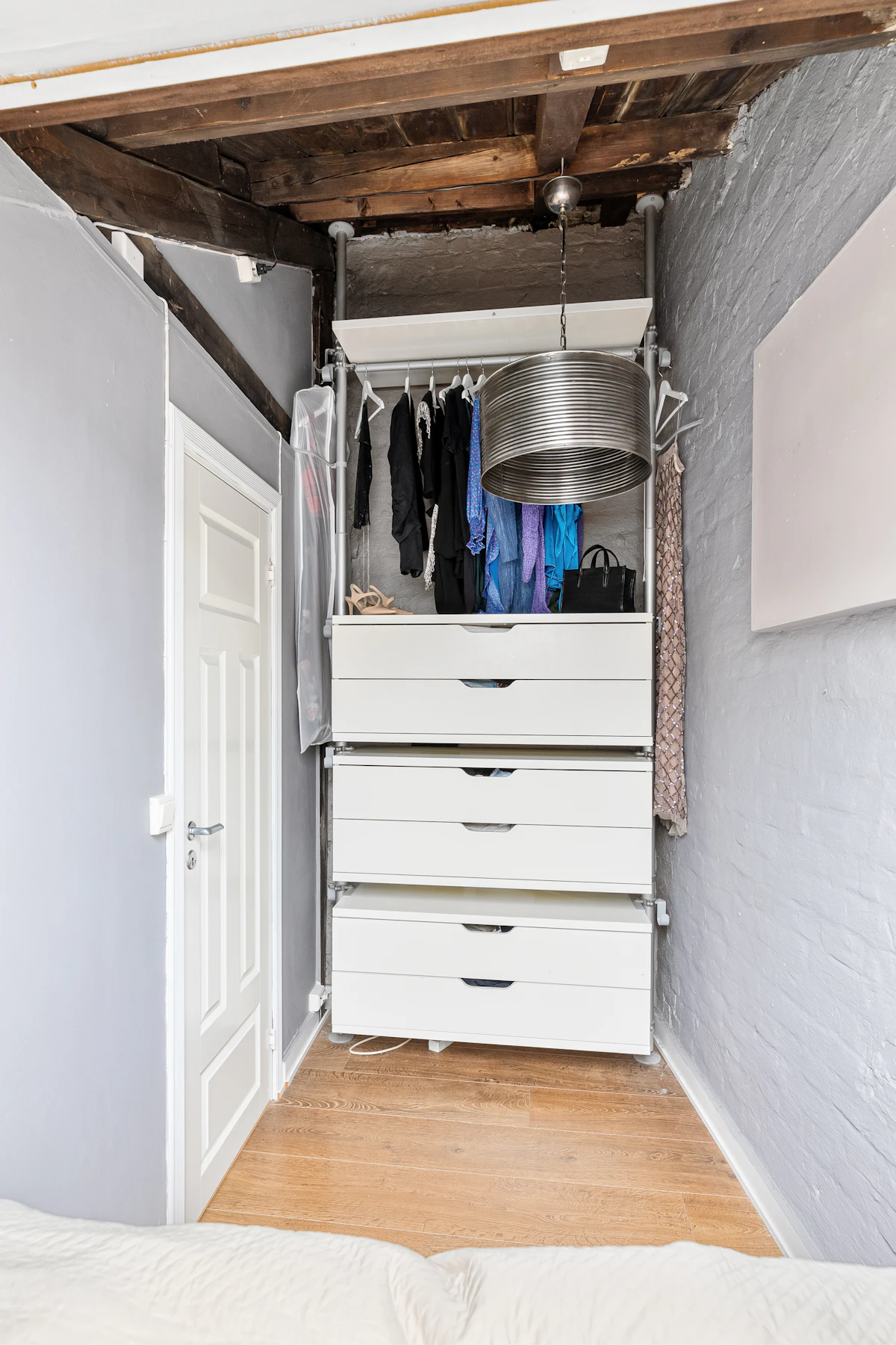Compact bedroom closet with shelves, hanging clothes and drawer storage