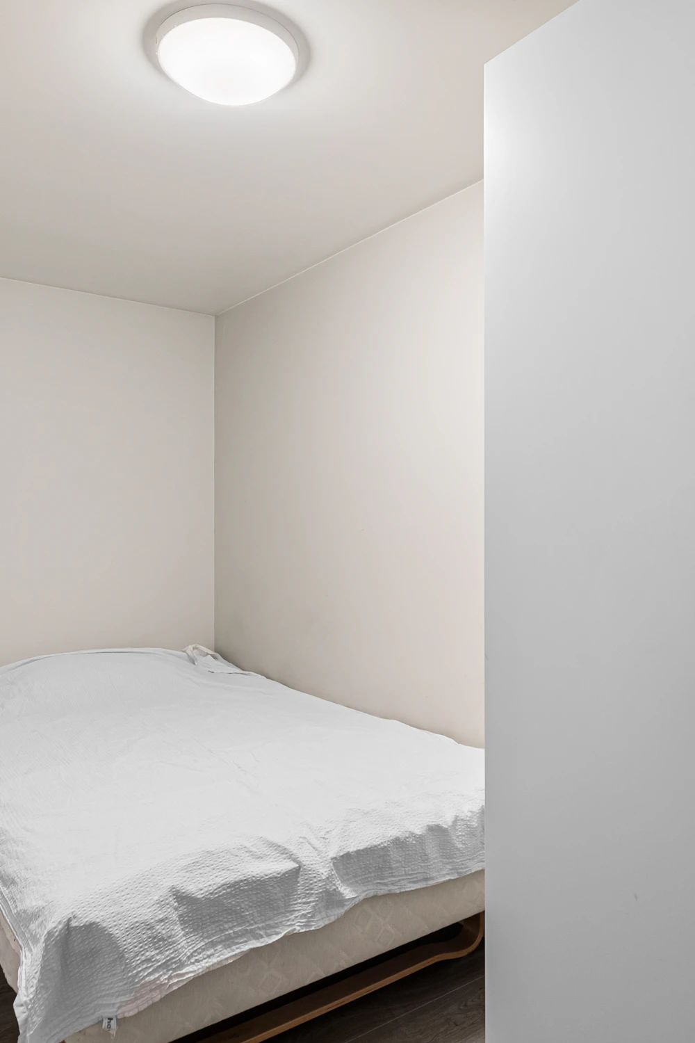 Small bedroom storage planning with a compact bed and nearby furniture