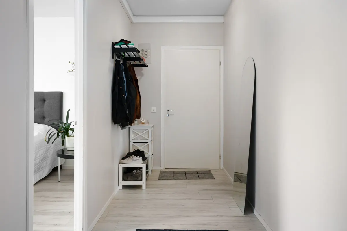Small entryway organization without a closet in a narrow apartment corridor